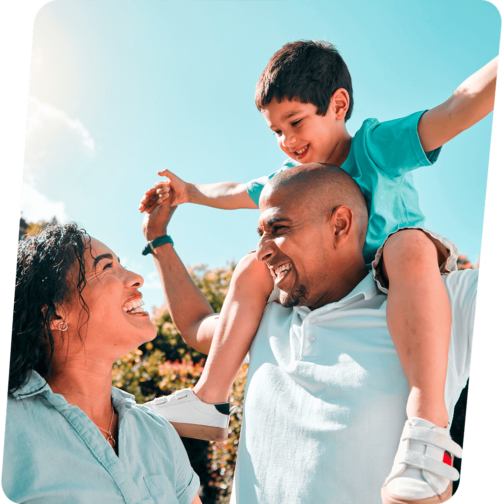 Subjective camera angle of a friendly male doctor in his 50s with glasses and a beard, talking to a female patient in a bright, modern clinic. Warm, natural lighting with subtle yellow and blue highlights, creating a feeling of trust and care. Defocused plant in the foreground.